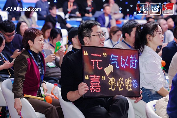 后援团举出“元气以赴，嘉油必胜”的牌子为杨元嘉加油鼓劲